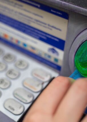 Eine Bankkundin steckt ihre Girokarte in einen Geldautomaten. (zu dpa: «Weniger Betrugsschäden mit der Girocard»)