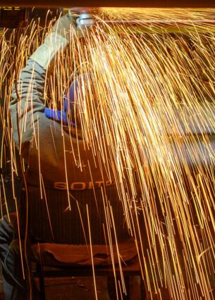Ein Werftarbeiter der Schiffbau- und Entwicklungsgesellschaft Tangermünde (SET) schleift in der Werft den Kiel einer Fähre, die dort gebaut wird. (zu dpa: «Ifo: Stimmung in ostdeutschen Unternehmen steigt wieder»)