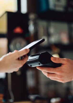 In einem Geschäft witd kontaktlos bezahlt mir dem Handy