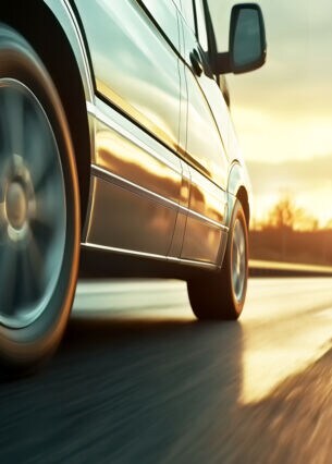 Auto fährt über die Straße bei Sonnenuntergang