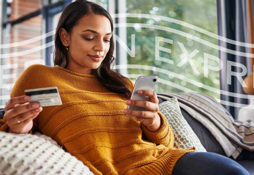 Woman on couch with Card looking at phone