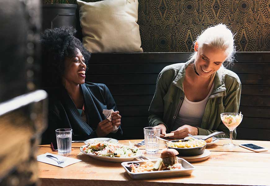 Woman paying with Tap to Pay at restaurant with friends