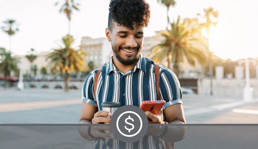 A Black man in a striped shirt holds a thermos in one hand while he makes a payment on his red mobile phone in the other.