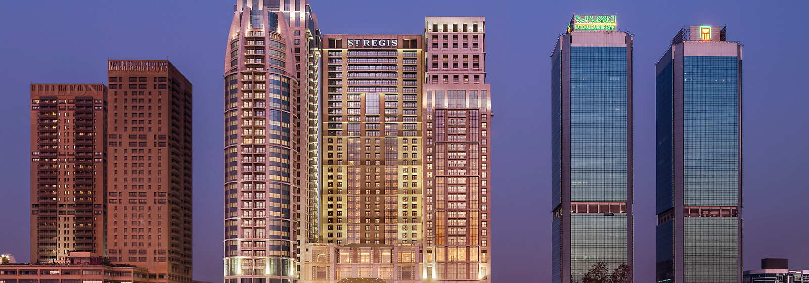 The iconic St. Regis Cairo rises tall, overlooking the timeless river Nile and the bustling city of CairO.