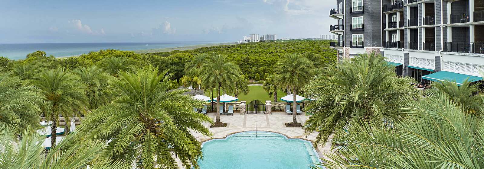 View of the resort hotel that overlooks the Adults-Only Pool, Grand Lawn, and neighboring State Park and Emerald-water Gulf Coast.