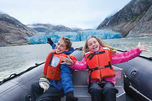 Kids learning to drive a Zodiac in Alaska with Lindblad Expeditions 