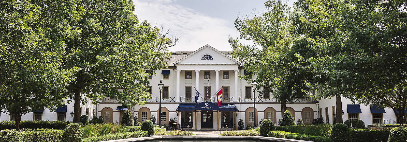 The iconic entrance to the Williamsburg Inn, with the reflection pool in sight, at Spring.