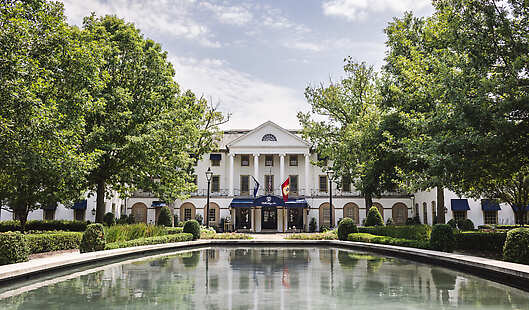 The iconic entrance to the Williamsburg Inn, with the reflection pool in sight, at Spring.