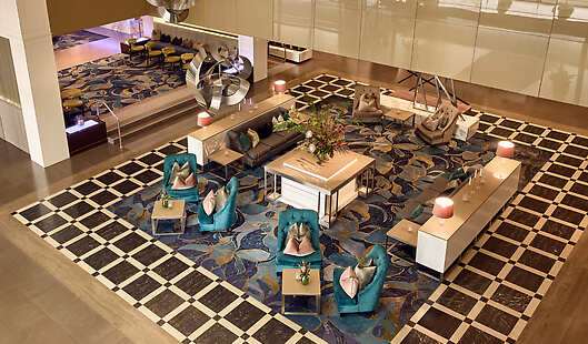 Grand Lobby of Sofitel Brisbane Central with big florals in the centre table and access to the Cuvée Lobby Bar