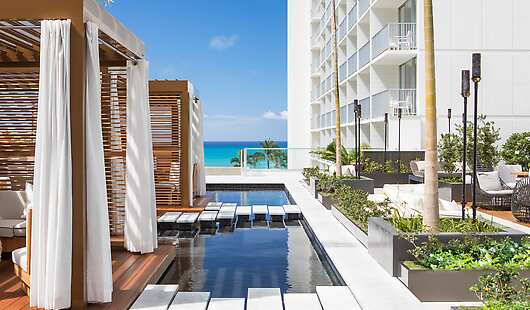Private cabanas perched atop reflecting pools on the Swell pool deck.
