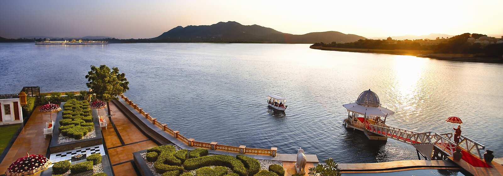 The Grand arrival of guests by boat to The Leela Palace Udaipur through the shimmering water of Lake Pichola into the main jetty