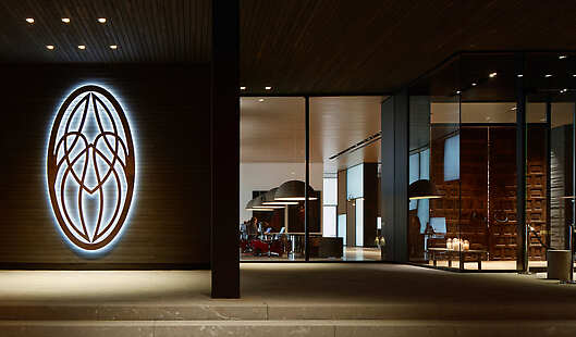 entrance of the hotel with iluminated hotel emblem.