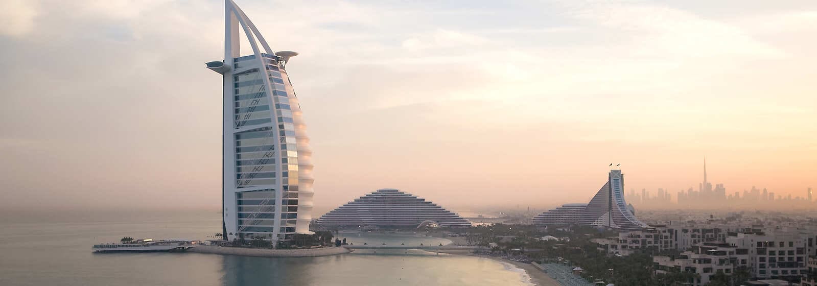 The Burj Al Arab, often referred to as the world's only 10-star hotel,  stands as a beacon of opulence and innovation. Situated on its own man-made  island off the coast of Dubai,, image size:1599x560