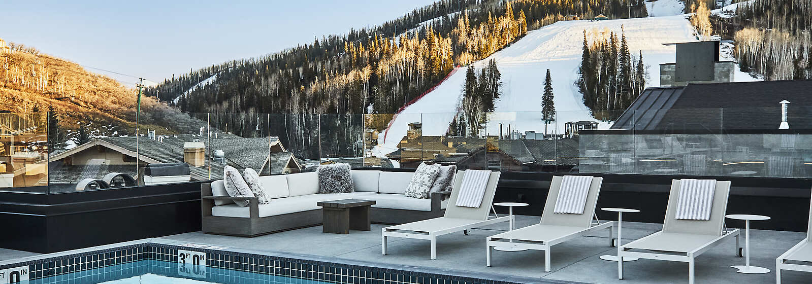 Outdoor heated rooftop pool overlooking snow covered ski slopes. 