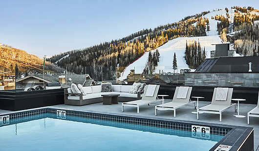Outdoor heated rooftop pool overlooking snow covered ski slopes. 