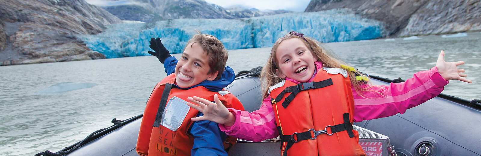 Kids learning to drive a Zodiac in Alaska with Lindblad Expeditions 