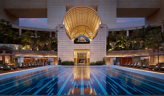 As the sun sets, relax over a cocktail at the swimming pool of The Ritz-Carlton, Millenia Singapore.