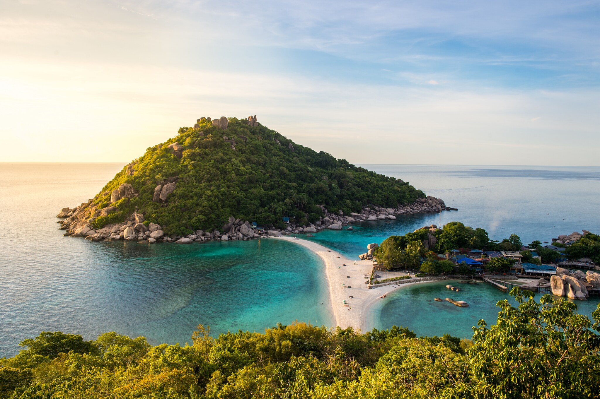 View from a lush hillside of a narrow spit of sand forking to two small, forested islands off of Ko Tao.