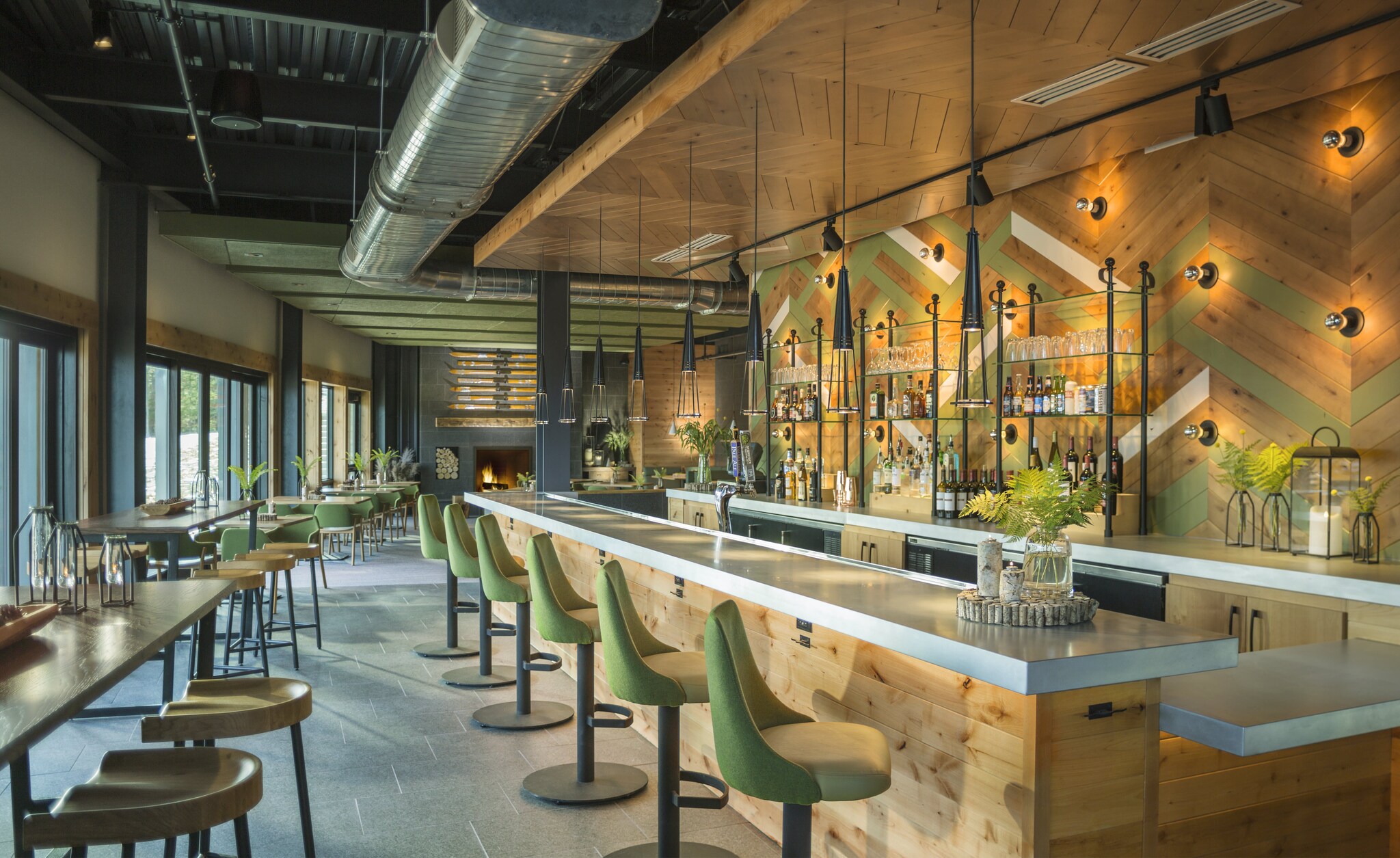 The Switchback Grille near the hotel is decorated in light brown wood with light green accents. High stools are lined up along a white bar.