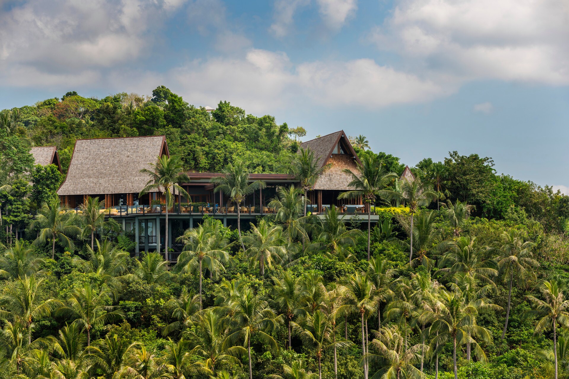 The Four Seasons Resort Koh Samui, with sharply steepled roofs and wide, modern lines on its lower floors, rises out of a hillside of palms.