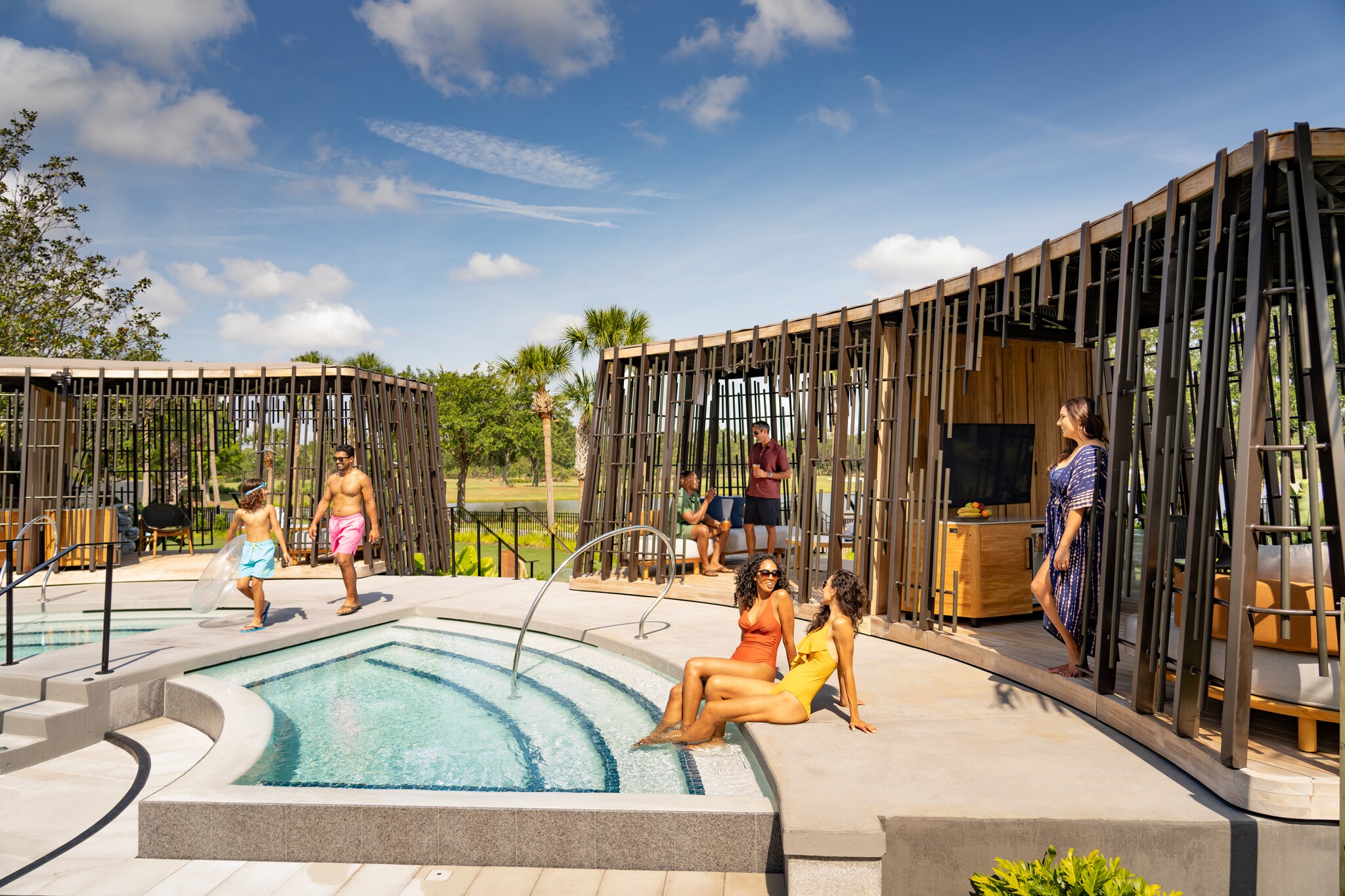 Tanned vacationers stretch out in brightly colored swimwear and flowy clothes, both in lattice-walled cabanas and by small pools.