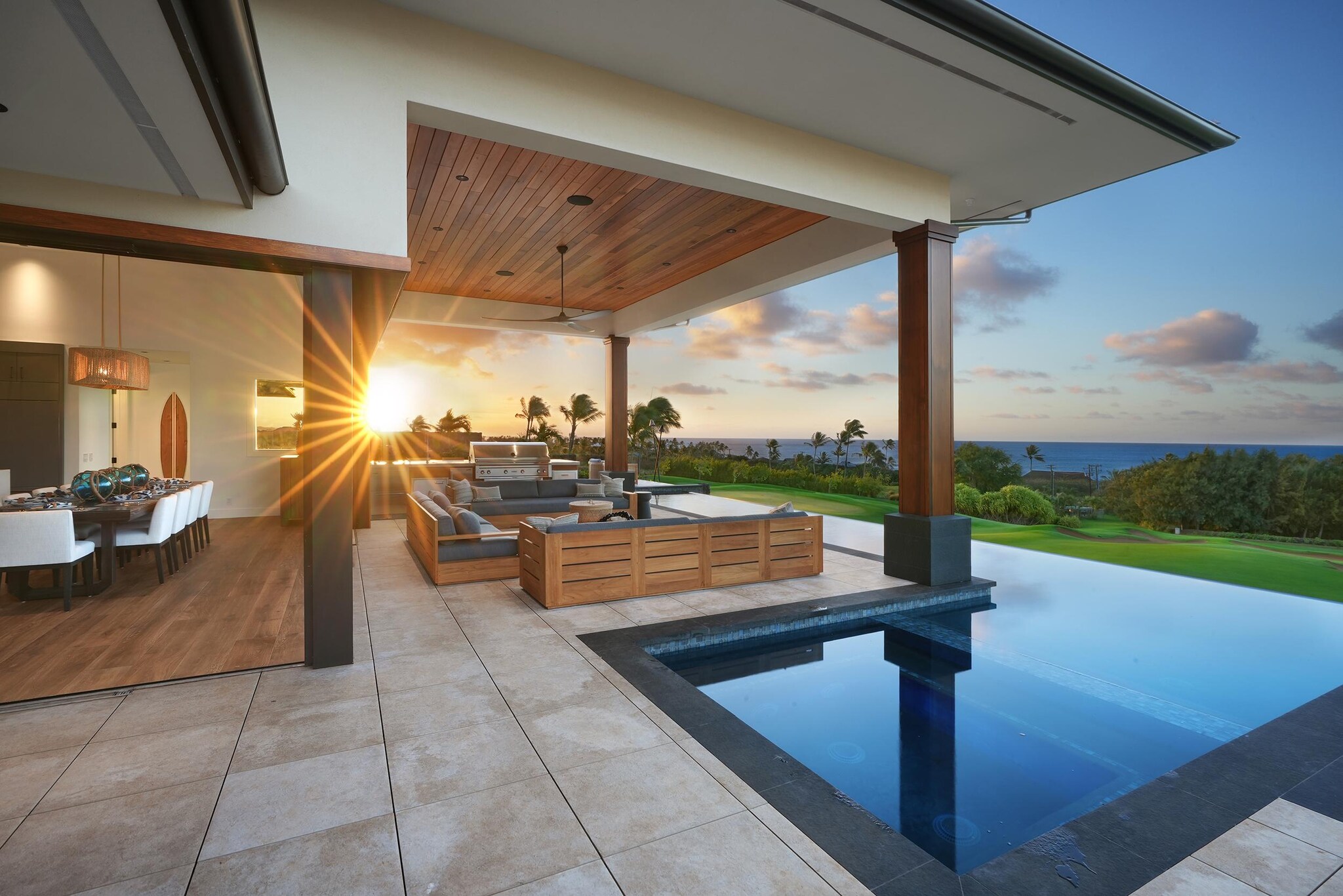 Outdoor dining and BBQ area and swimming pool with view of ocean.