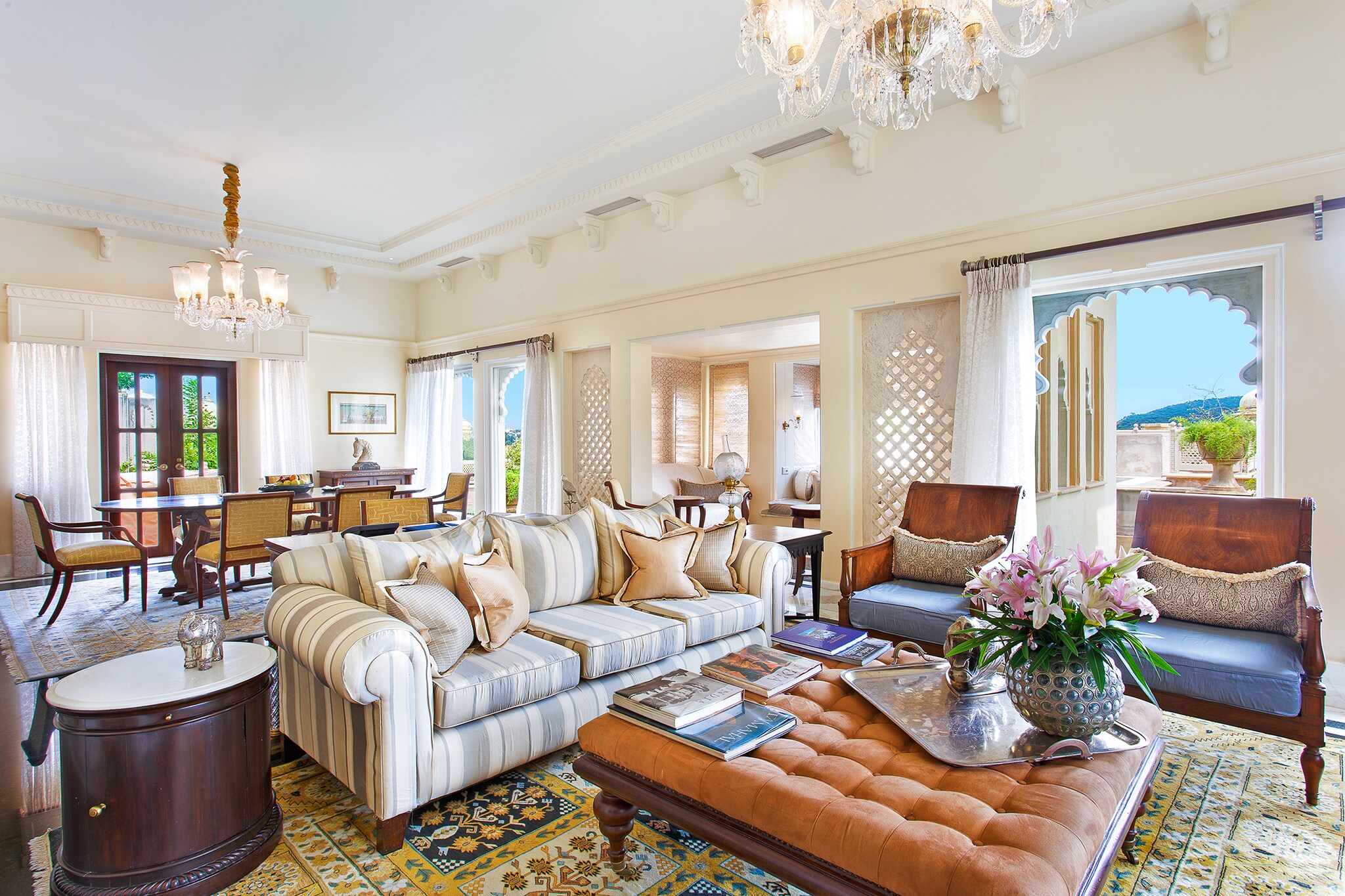 The living area of the Kohinoor Suite is decorated sumptuously, with plush furnishings, ornamental windows, and a crystal chandelier.