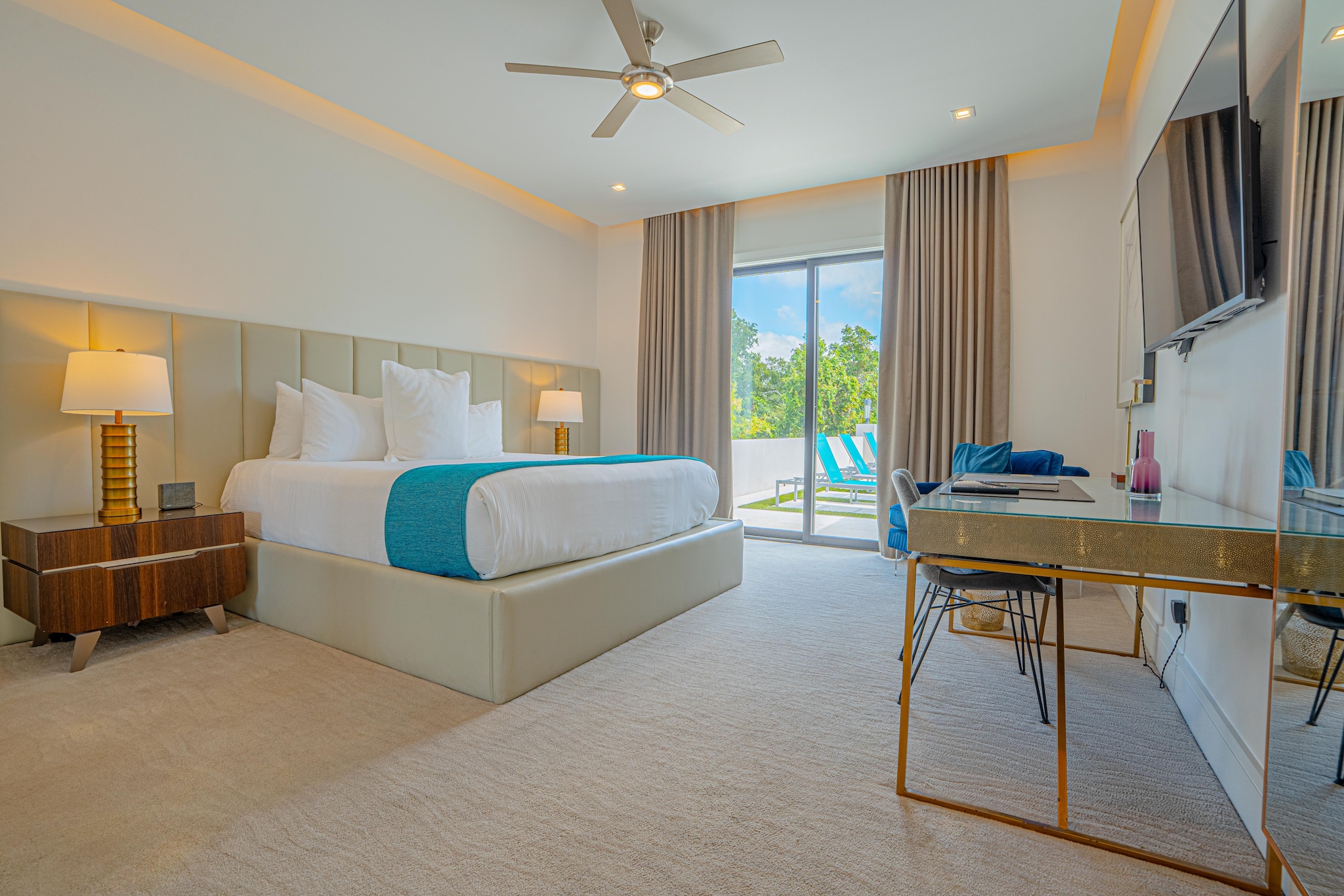 Large bedroom with access to swimming pool through sliding glass door.