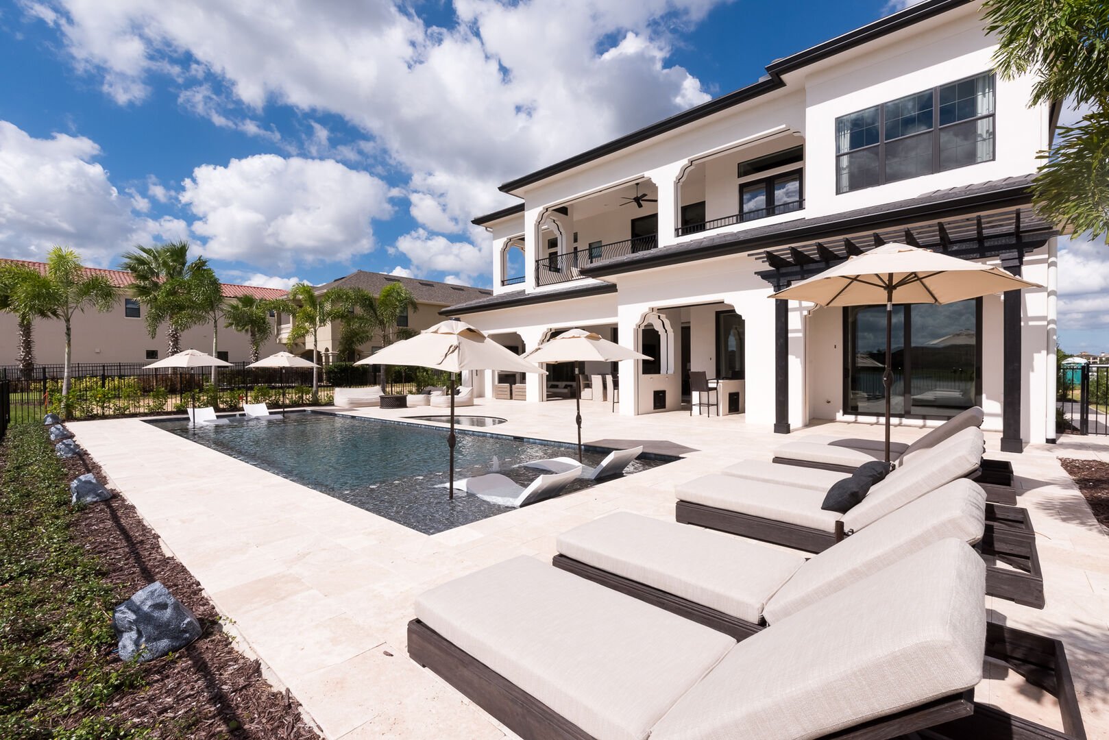 Exterior of two-story house backyard featuring large swimming pool.