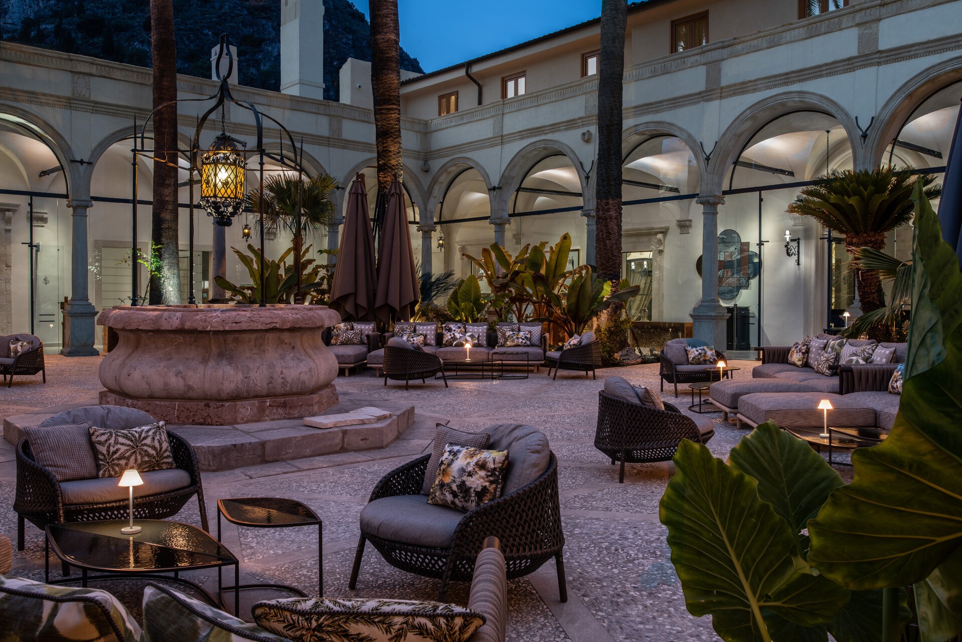 The cloister left from the property’s days now features black and gray outdoor furniture arranged in clusters with small lamps.