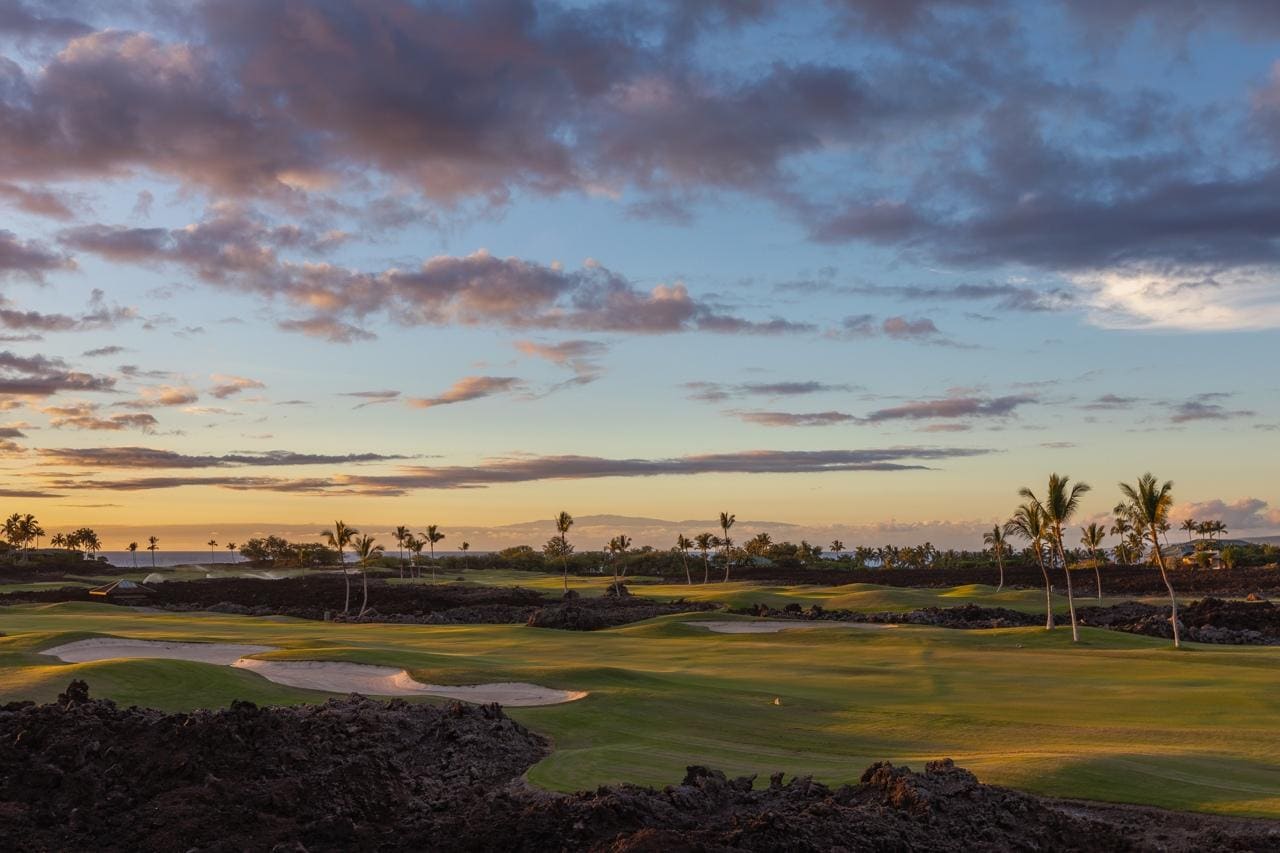 Aerial view of golf course at sunset.