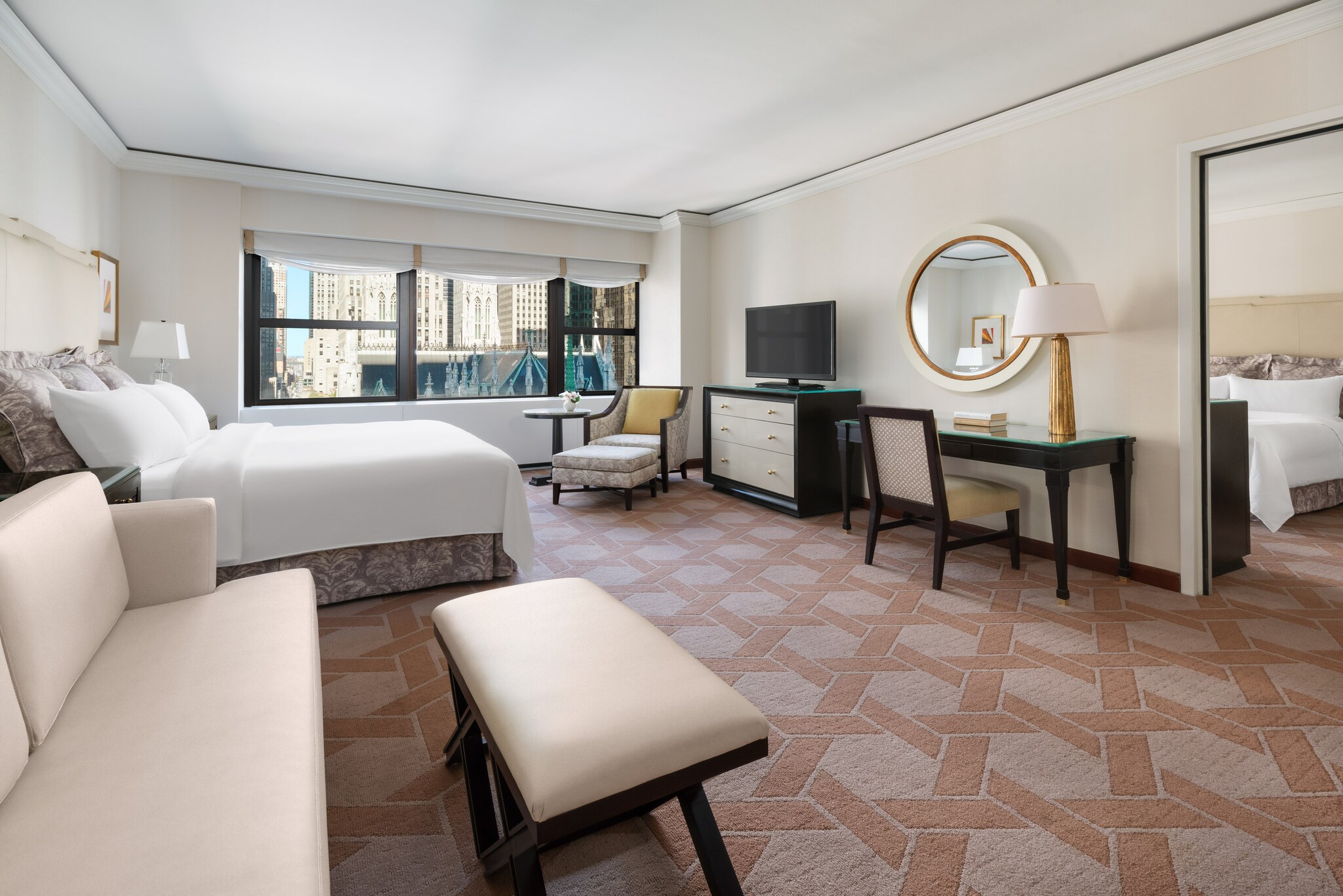 The expansive Palace Family Suite has a two-tone pink carpet, with black, glass-topped furniture and gold trim.