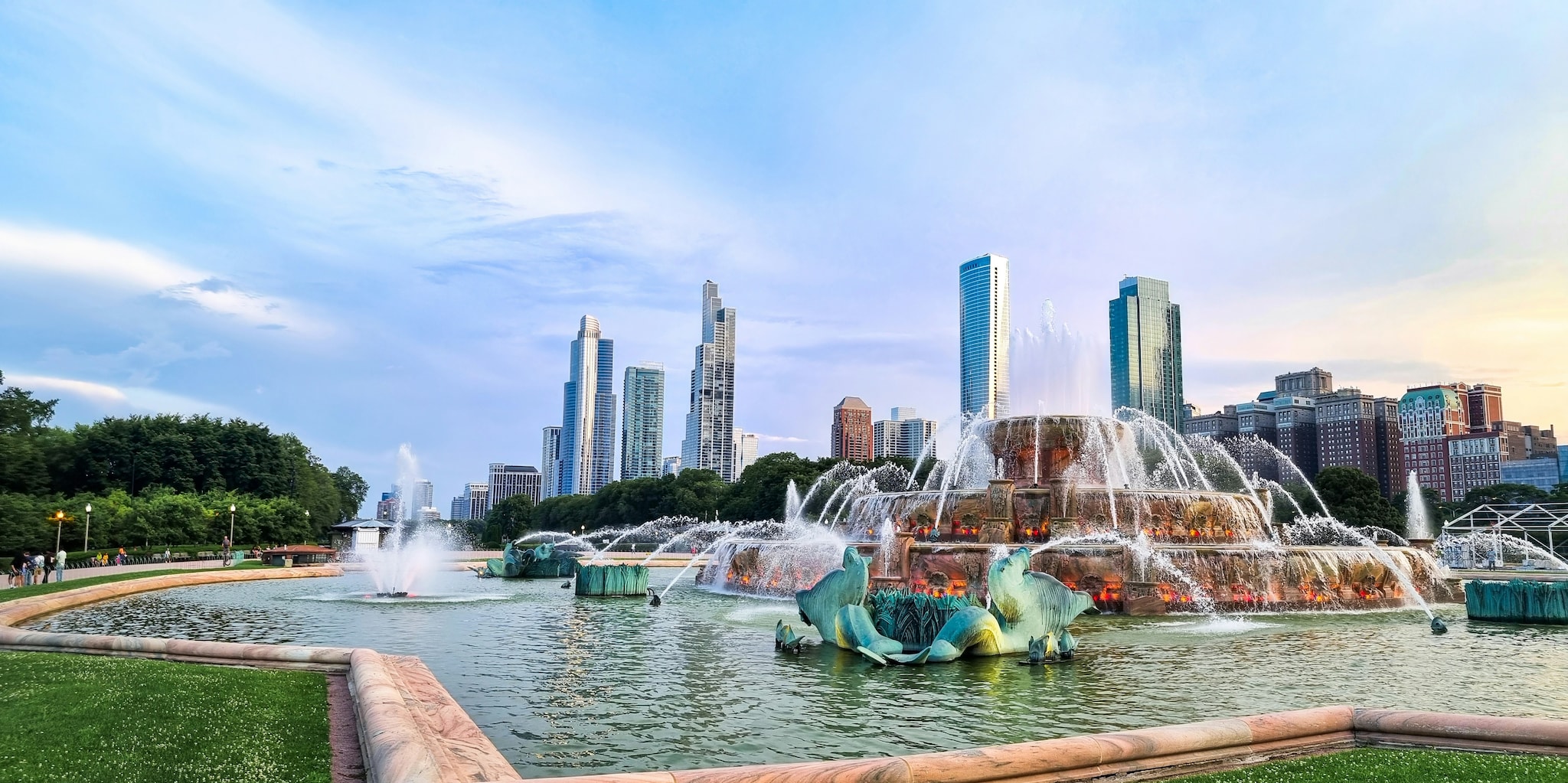 Buckingham Fountain in Grant Park features a tiered central fountain and spouting seal statues. The city skyline is visible beyond.