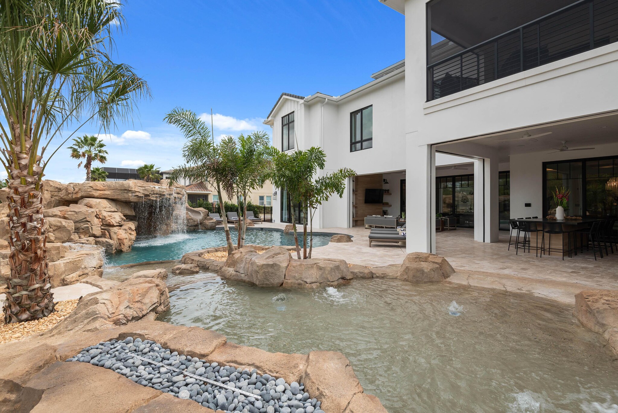 Exterior view of large two-story vacation rental property showcasing outdoor swimming pool and patio