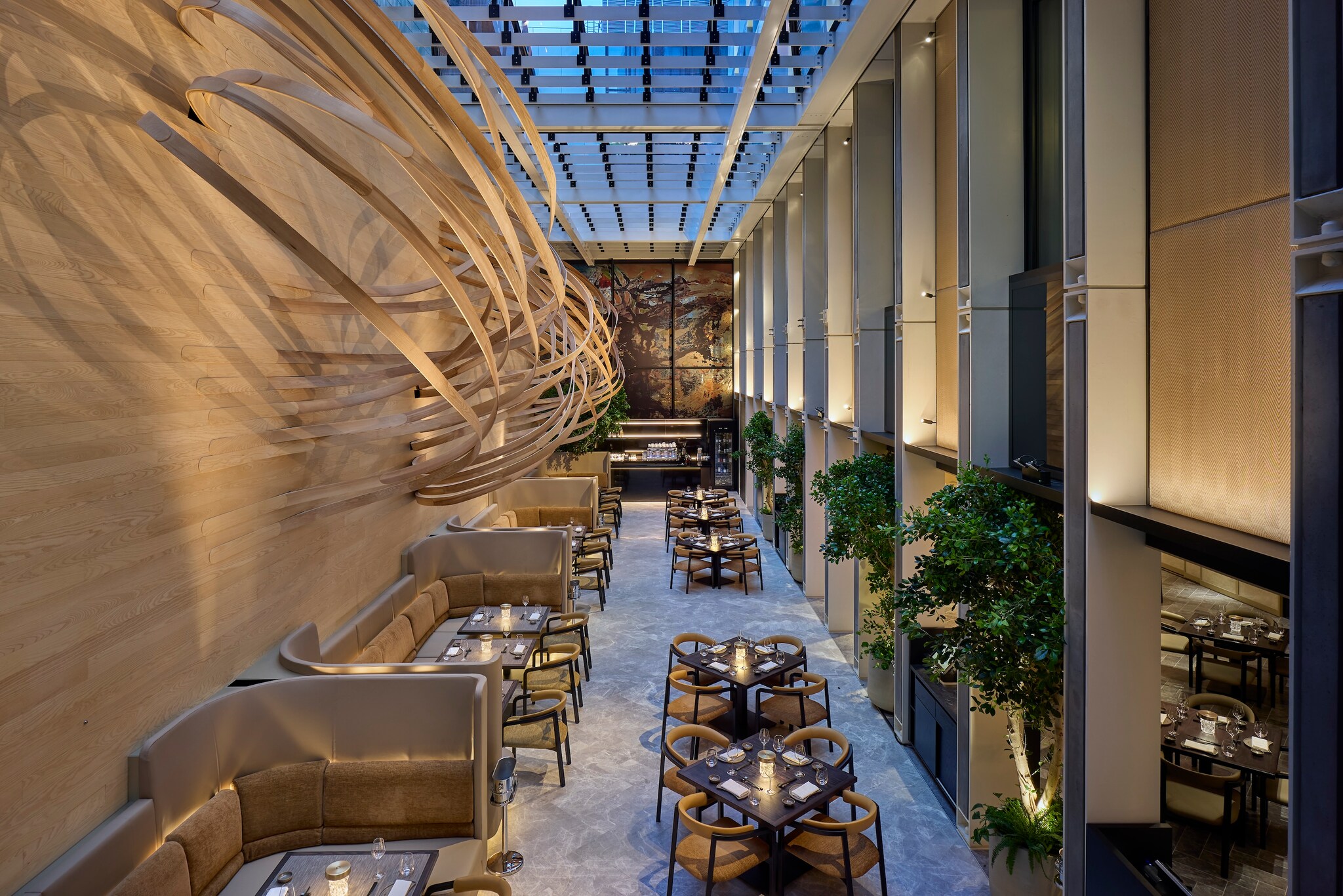 Akira Back restaurant is in a long, high-ceilinged room with pale wooden slat paneling and sculptural wooden wall installations.