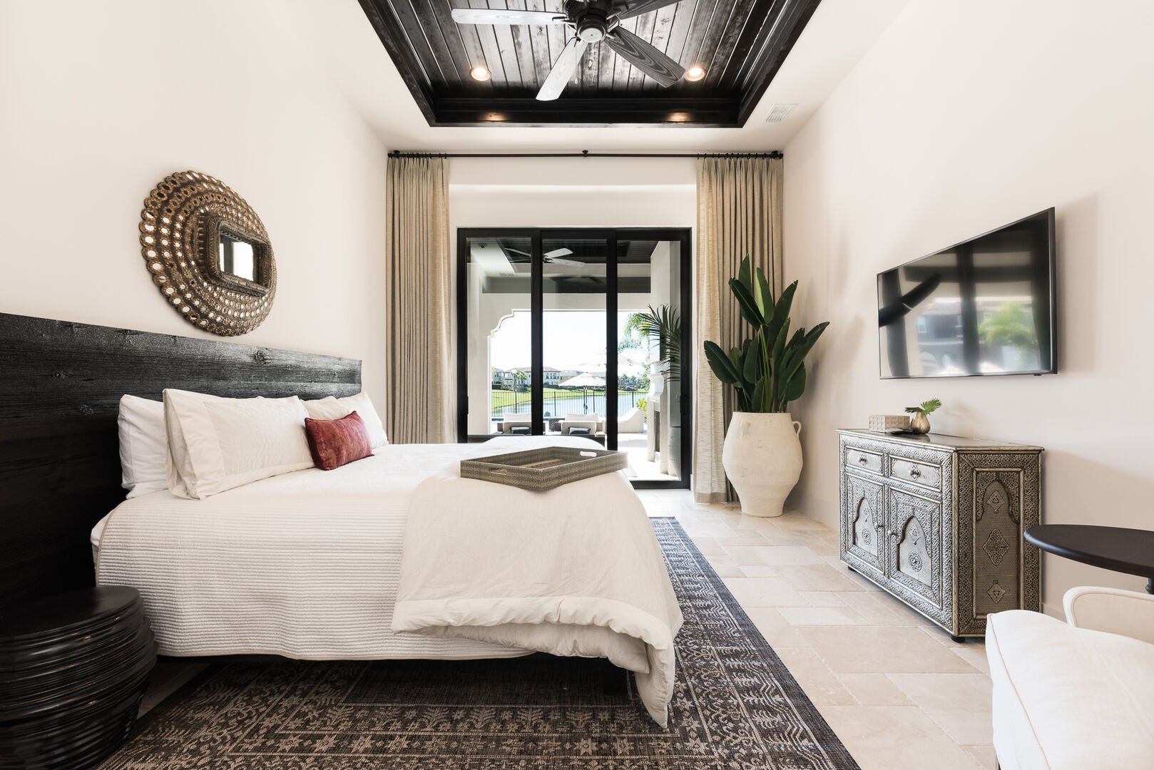 Large bedroom with access to swimming pool through sliding glass door.