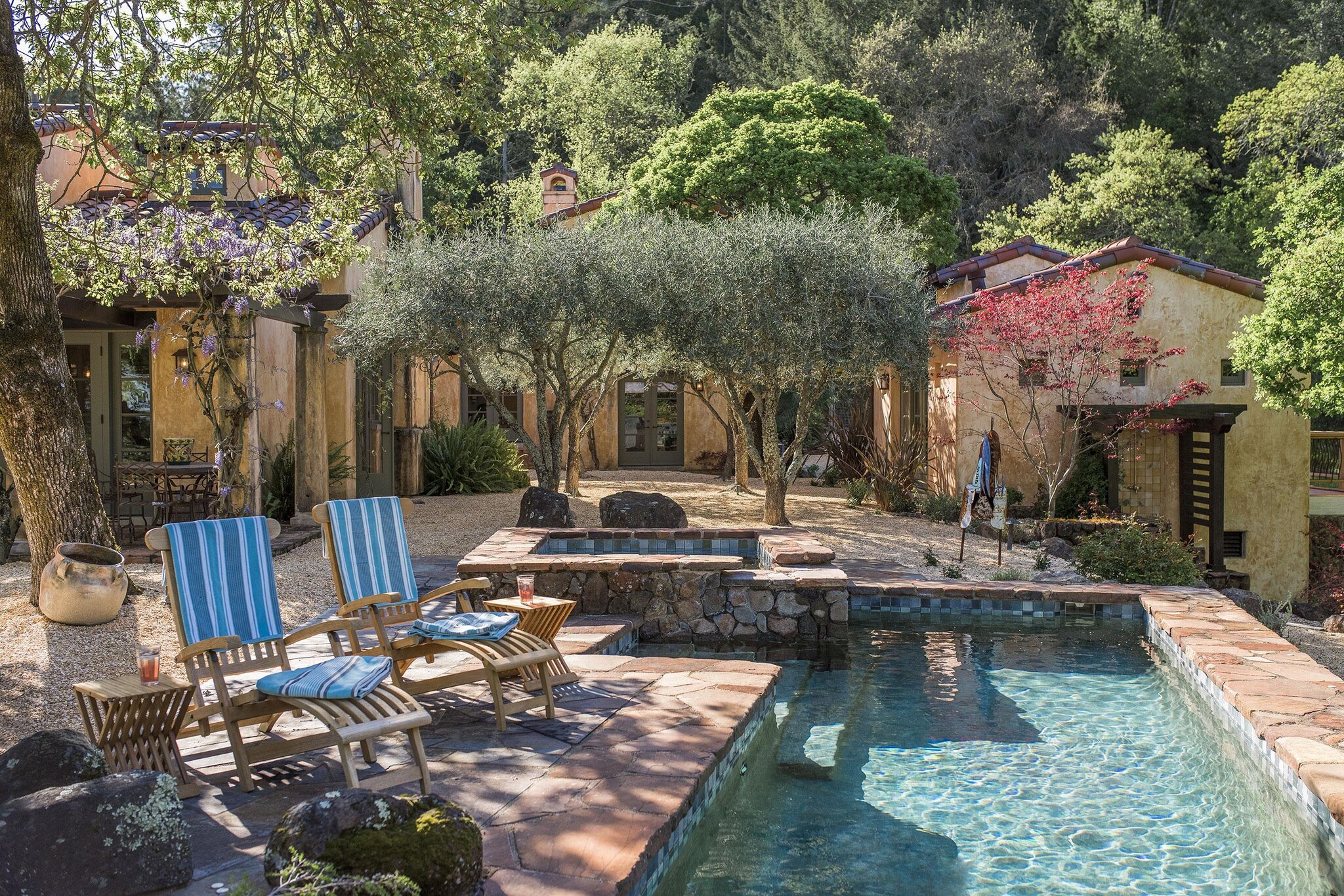 Exterior of Spanish-style ranch house with view of outdoor swimming pool.