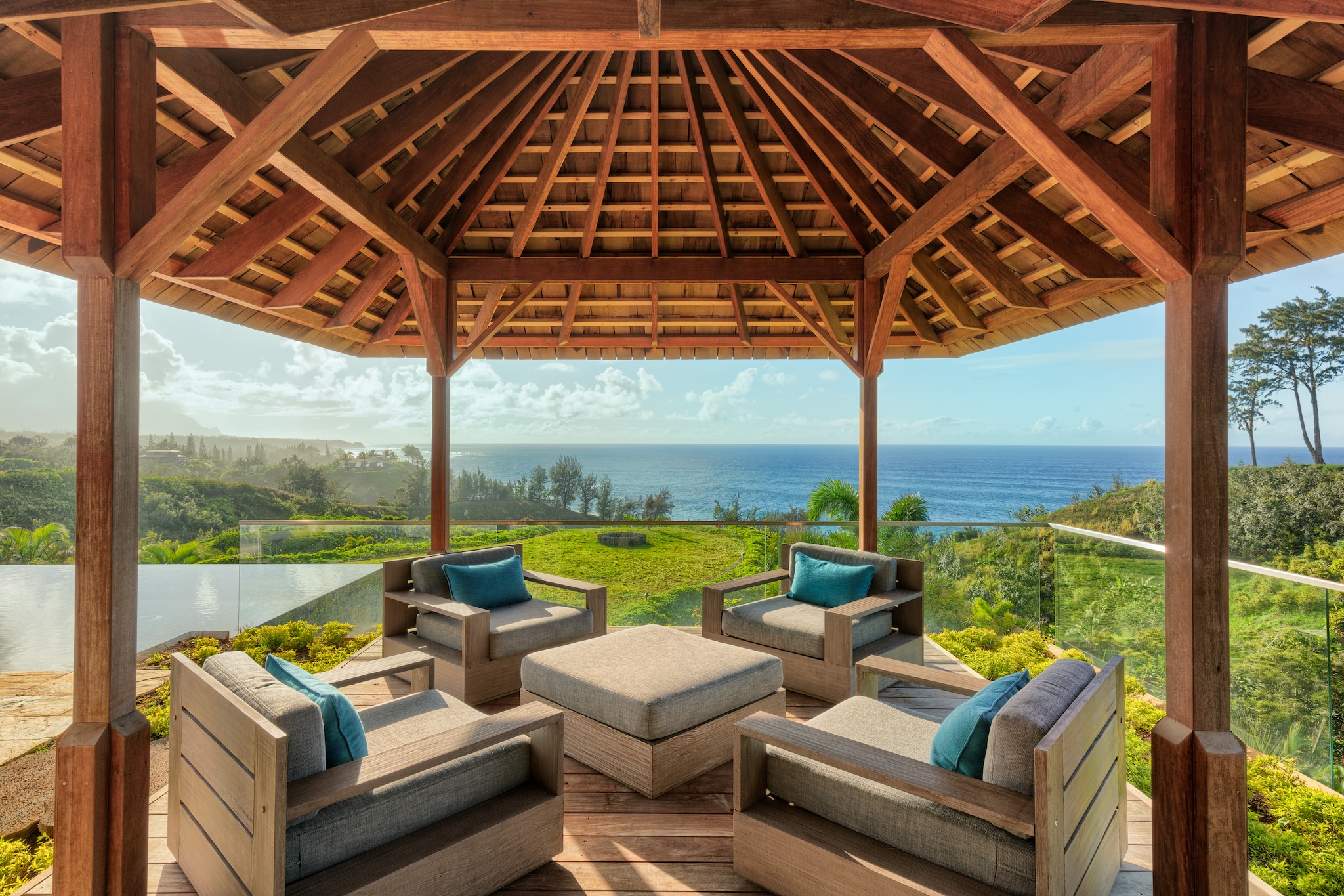 Outdoor pergola seating with view of swimming pool overlooking the ocean