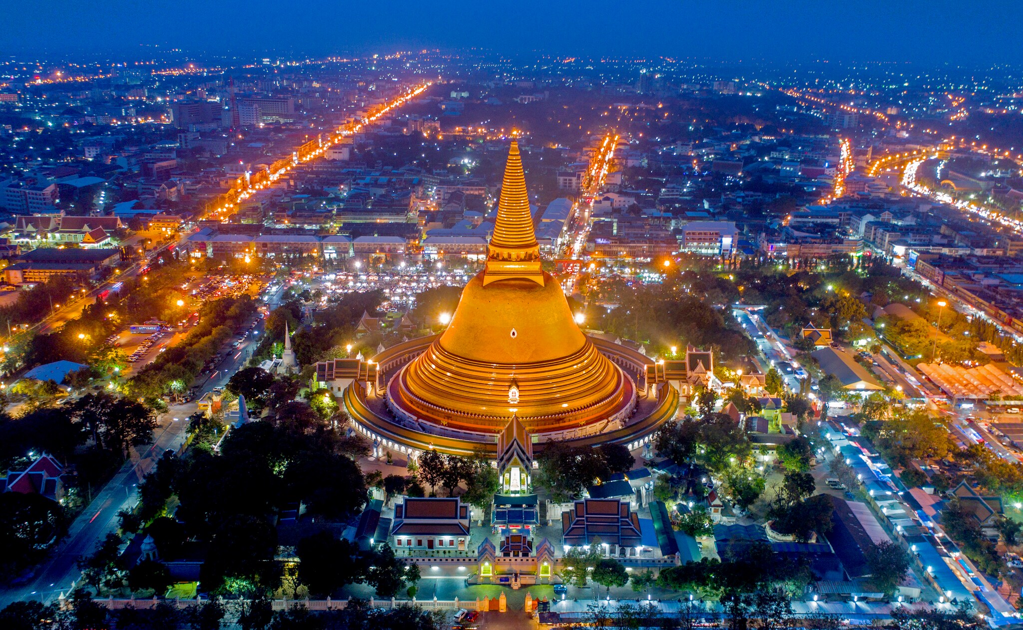 Aerial view of the Phra Pathommachedi, a gigantic bell-like golden stupa, lit up in the evening in central Nakhon Pathom near Bangkok.