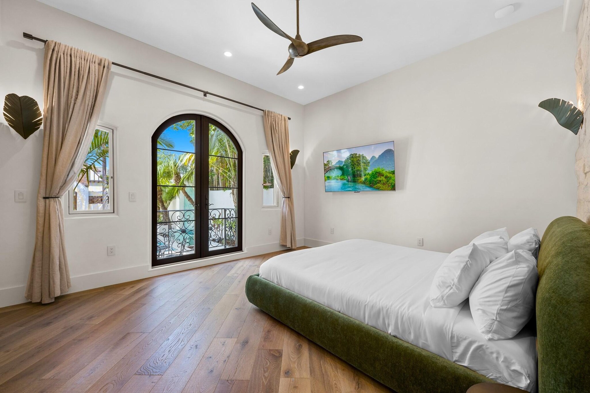 Bright interior of Spanish-style bedroom with arched doorway leading to outdoor patio