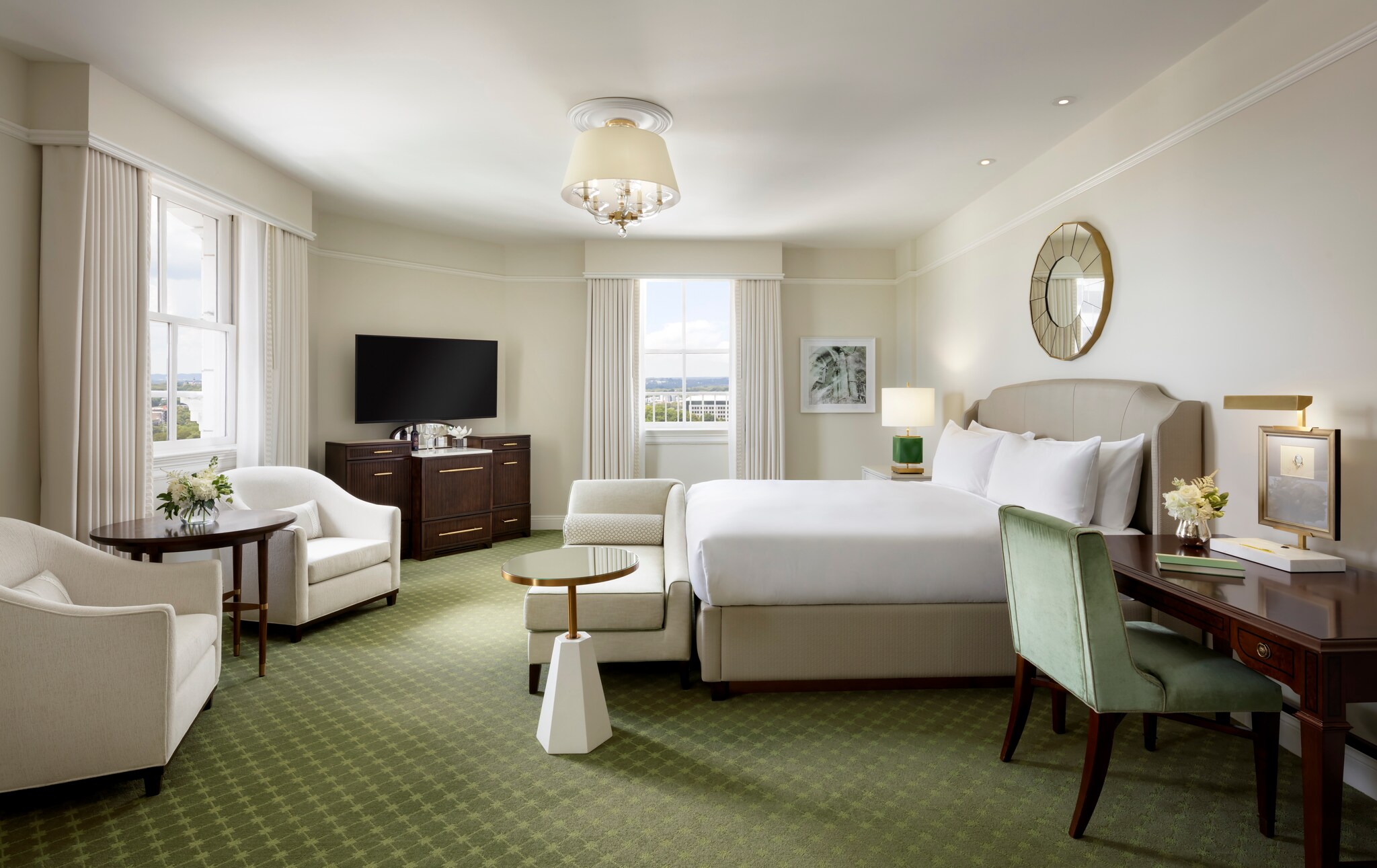 A spacious guest room has white walls and furniture with dark brown and light green accents, including a diamond-patterned green carpet.