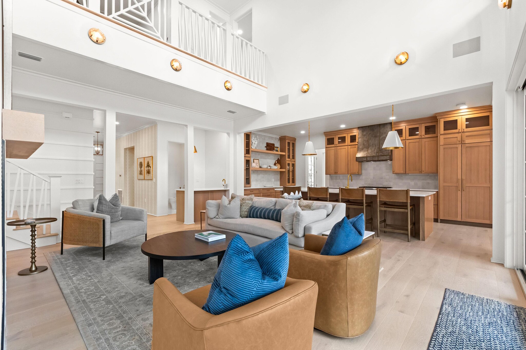 Bright and modern kitchen, dining, and living area of two-story house with two-story ceiling.