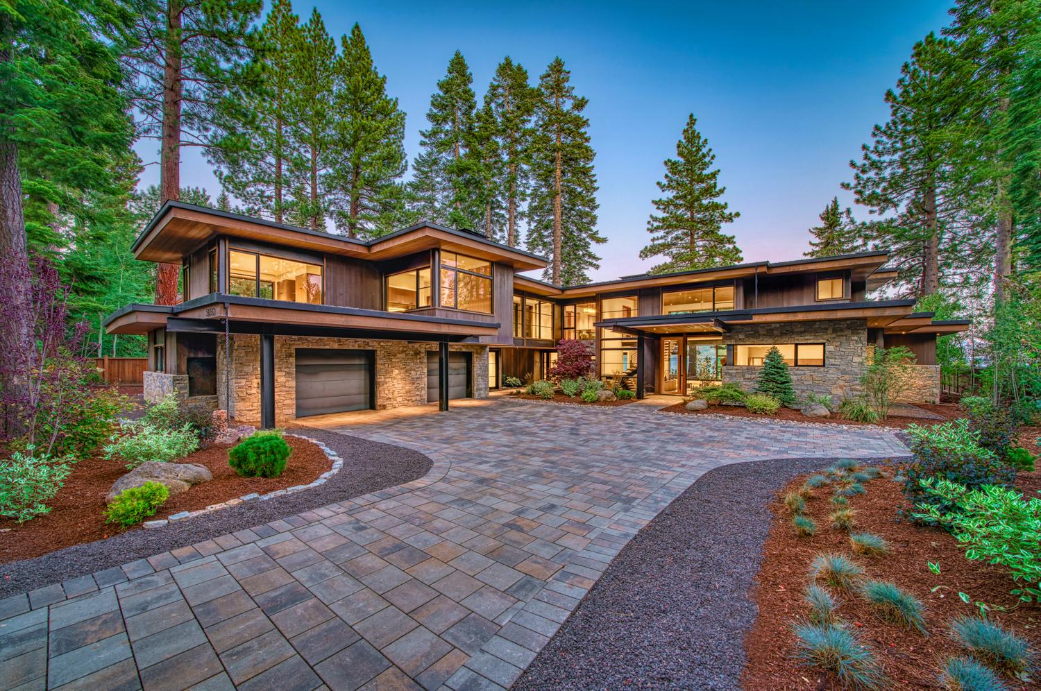 Exterior of large lodge-style home set amongst mature trees.