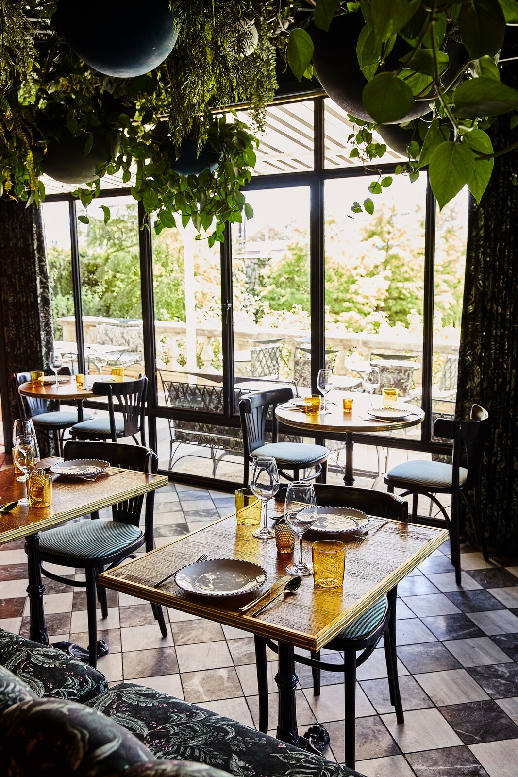 Tables inside Lutie’s Garden feature chic clear-and-ochre glassware, and expansive windows look out on verandah seating and gardens.