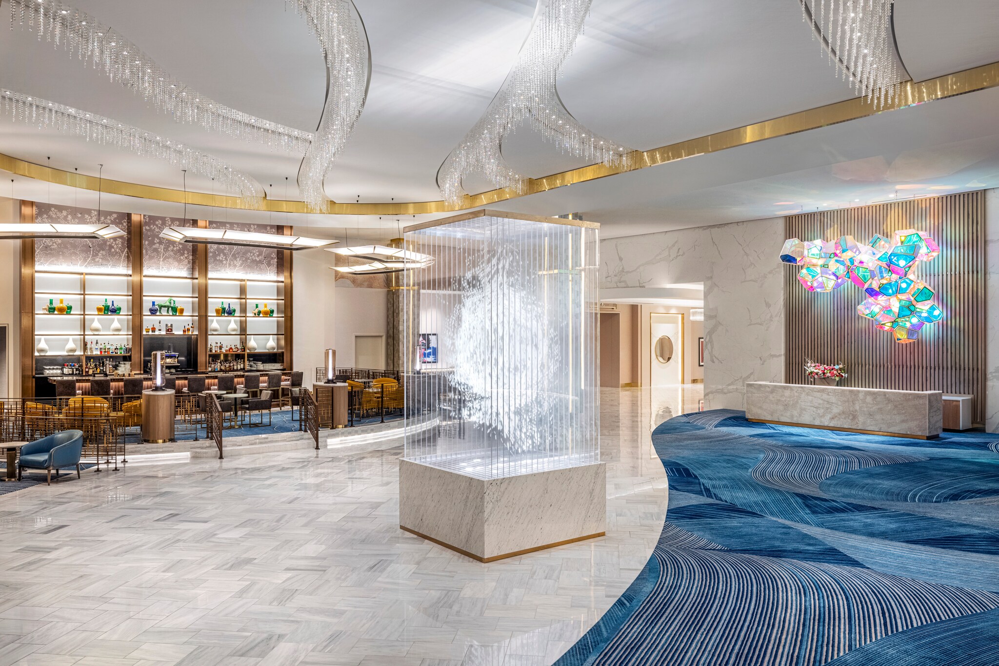 The Conrad Las Vegas Lobby is glittering, with crystal beads hanging from the ceiling and a wispy white art installation in the center.