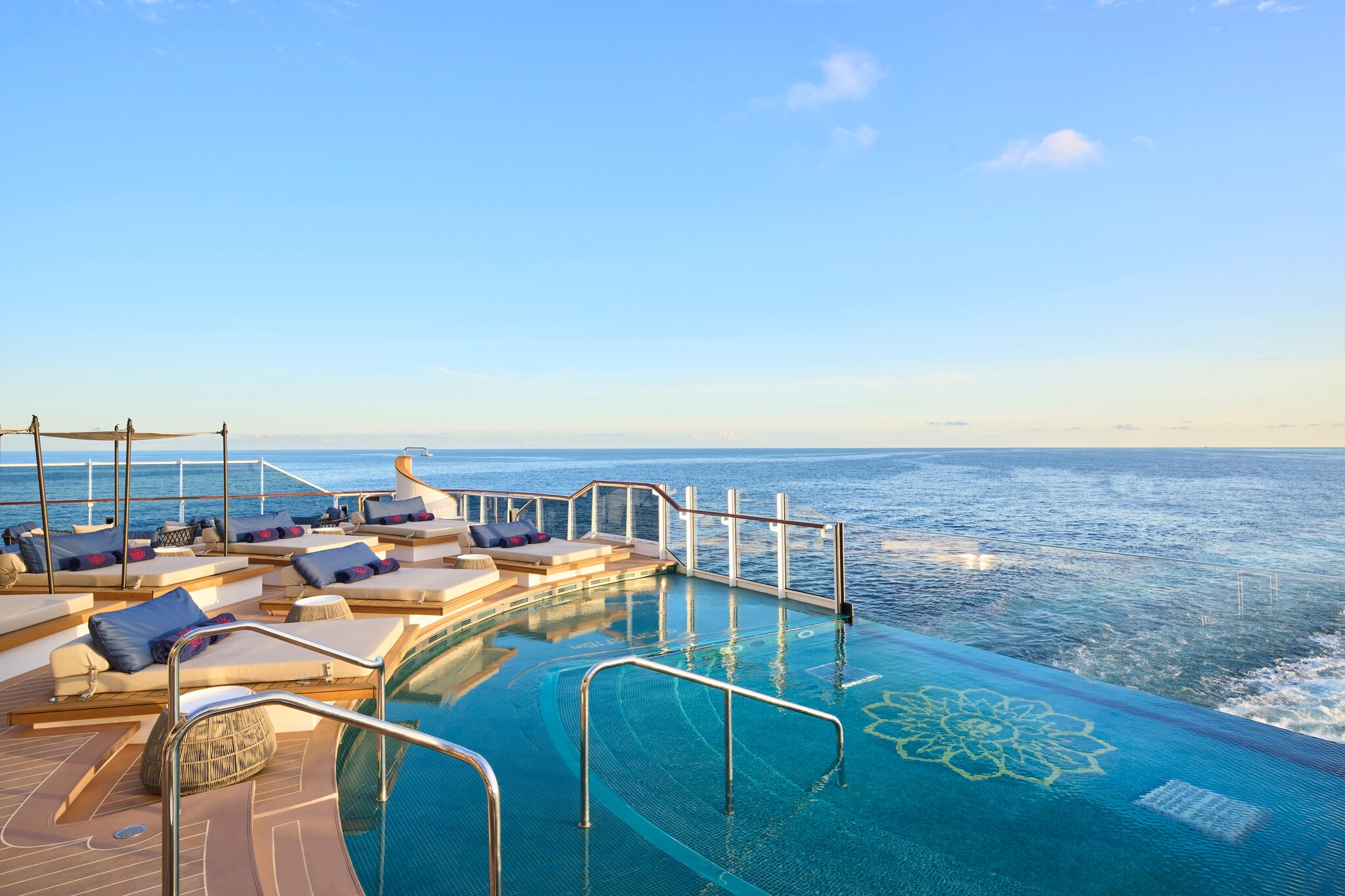 A semicircular pool with a lotus motif on its floor looks through a class wall off the back of the ship.