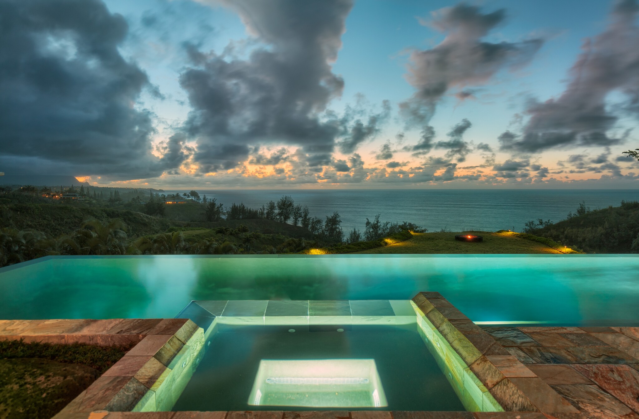Aerial view of outdoor swimming pool overlooking the ocean at dusk