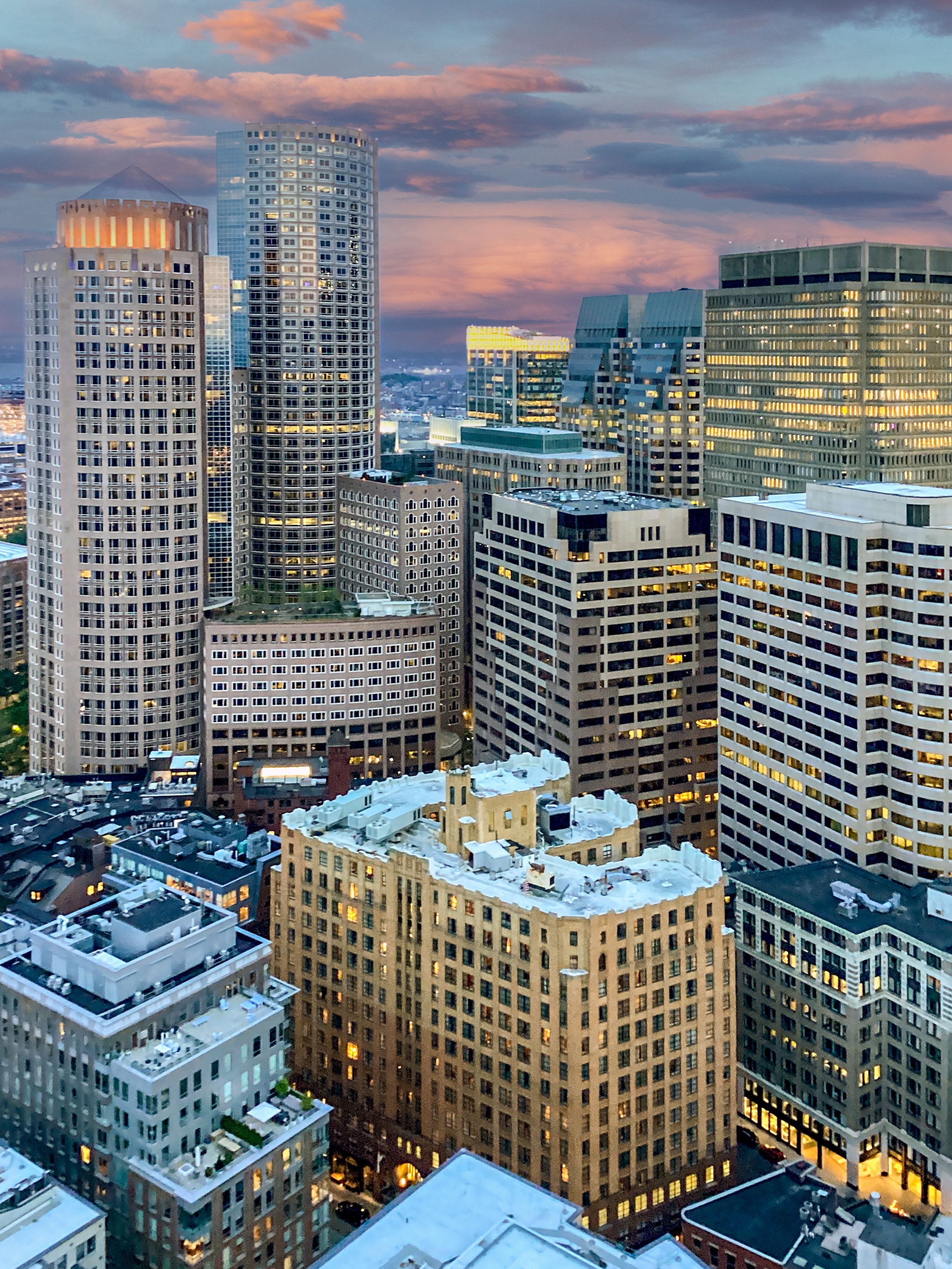 Aerial view of the skyscrapers of Boston’s South End, lit up and reflecting the golden sunset as the day ends.