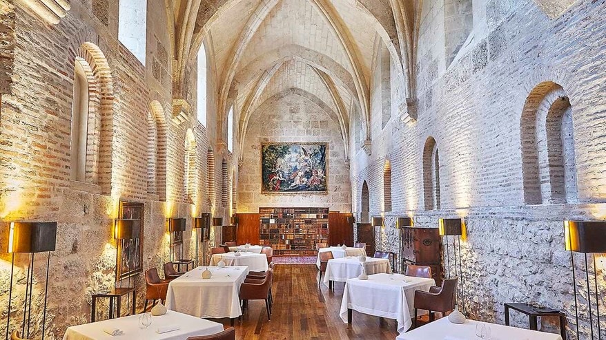 Brick and stone dining room with vaulted ceilings and paintings