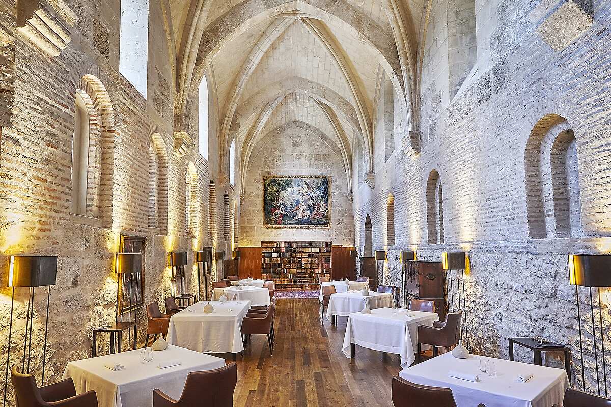 Brick and stone dining room with vaulted ceilings and paintings